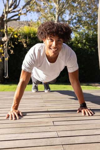 Man Smiling While Doing Push-Ups on Outdoor Deck