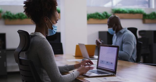 Employees Working with Laptops Wearing Masks in Modern Office - Download Free Stock Images Pikwizard.com