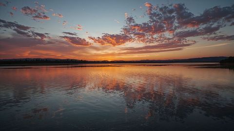 Serene Lake at Sunset with Reflective Clouds and Fiery Sky