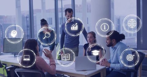 Creative Team Collaborating in Modern Office Around Laptop with Business Icons