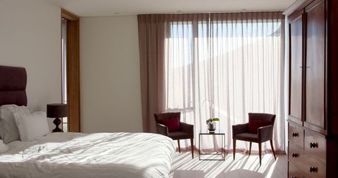 Sunlit Modern Bedroom with Plush Furniture and Sheer Curtains - Download Free Stock Images Pikwizard.com