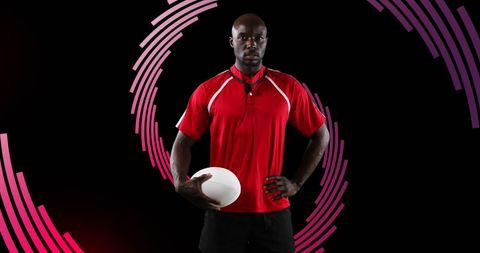Confident rugby player holding ball with futuristic red spiral background