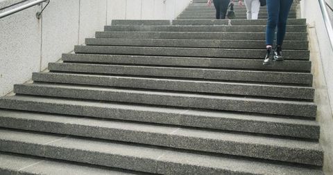 Commuters Descending Concrete Staircase in Urban Underpass with Minimalist Composition