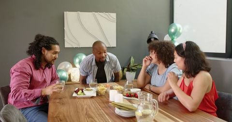 Diverse Friends Toasting During Home Celebration Gathering Around Table