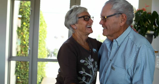 A senior Caucasian couple shares a joyful moment together, laughing and enjoying each other's company, with copy space. Their genuine happiness and affectionate interaction exemplify a deep bond and a lifetime of shared memories.