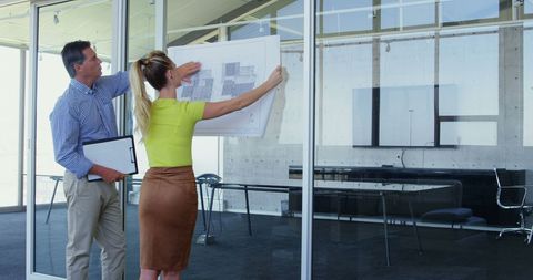 Architect team analyzing design blueprint in modern office