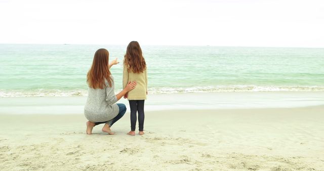 Mother and daughter looking at beach together