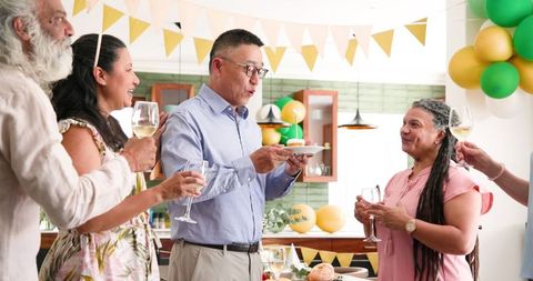 Senior Friends Celebrating Birthday with Cupcake and Toasting