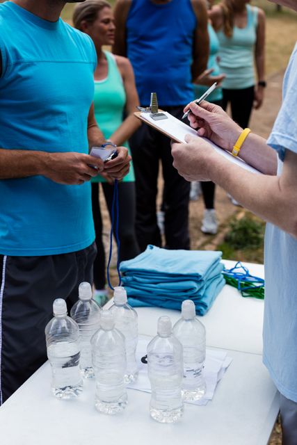 Mid section of volunteer registering athletes name for race in park