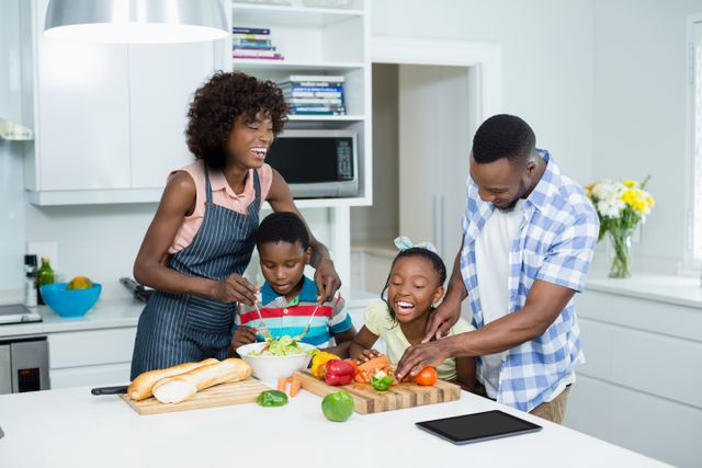 Parents and kids preparing salad in kitchen at home