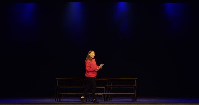 Young Woman Rehearsing Lines on Stage with Dramatic Lighting - Download Free Stock Images Pikwizard.com