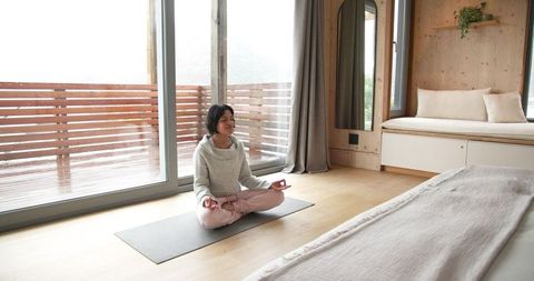 Young Woman Meditating in Cozy Bedroom for Inner Calmness