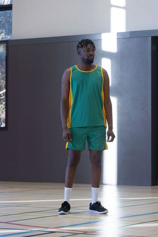 Basketball player practicing in sunlit indoor court