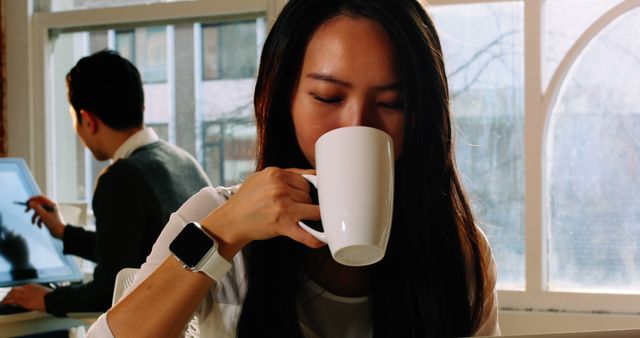 Businesswoman Drinking Coffee in Modern Office - Download Free Stock Images Pikwizard.com