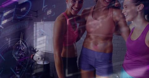 Three women celebrating workout in industrial gym with dumbbell rack and futuristic hud