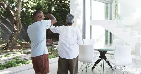 Senior couple enjoying dance near modern home garden view