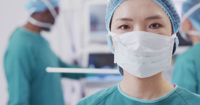 Shows an Asian nurse wearing a surgical mask in an operating room. Ideal for medical, healthcare, and educational materials focusing on surgical procedures, teamwork in a medical setting, and the professional environment in hospitals. Can be used for promoting health and safety protocols or illustrating articles about healthcare workers and operating room environments.