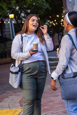 Friends chatting over coffee in urban evening plaza african american women connecting