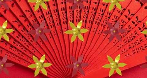 Intricate red Chinese fan featuring elegant floral designs showcased on a vivid red backdrop. Perfect for representing the essence of Chinese New Year celebrations, cultural festivals, or traditional art and design themes. Ideal for use in promoting Asian heritage events, creating themed decorations, or featured in design projects that emphasize classic ornamentation and traditional cultures.