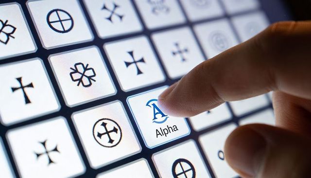 Tapping fingertip selecting Alpha key on backlit touchscreen grid for futuristic UI control