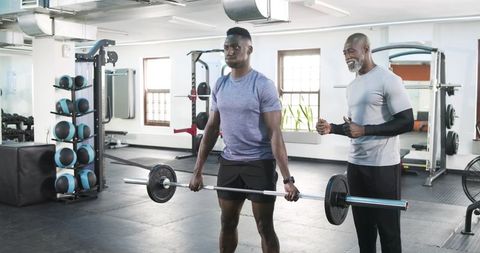 Personal Trainer Coaching Client with Barbell Workout Session