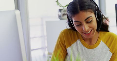 Smiling Woman with Headset Engaging in Remote Work at Home Office