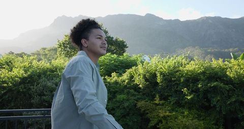 Woman Enjoying Tranquil Mountain View Amid Lush Greenery