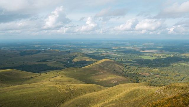 Idyllic Countryside and Rolling Green Hills Under Cloudy Sky