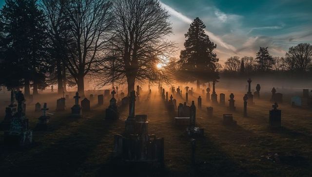 Serene Sunrise Over Misty Cemetery with Tombstones