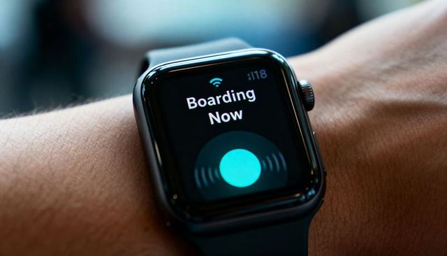 Smartwatch displaying boarding now notification on wrist for contactless boarding at airport