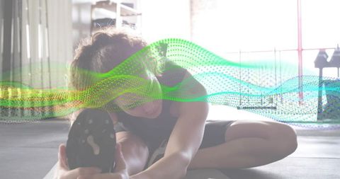 Backlit woman stretching on mat with colorful dotted wave overlay for fitness branding