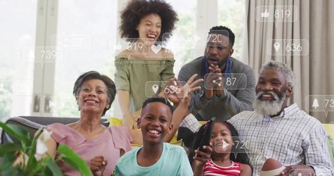 Multigenerational family celebrating on sofa with football, smiles and social icons