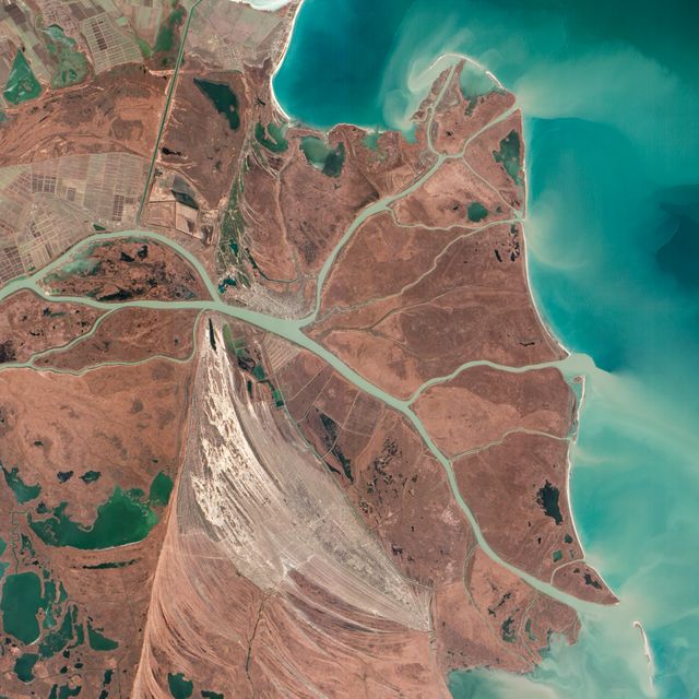This striking aerial view captures the northernmost Chilia lobe of the Danube Delta, which mainly lies within Ukraine, bordering the Black Sea. The delta is depicted with intricate waterways and wetlands. The image emphasizes natural features like beach ridges and canals and the significant human impact with settlements and navigation routes, providing valuable insights for ecological studies and conservation efforts. Suitable for educational, environmental, and geographic documentation.