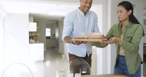 Couple Serving Breakfast on Wooden Tray in Bright Modern Open-Plan Kitchen