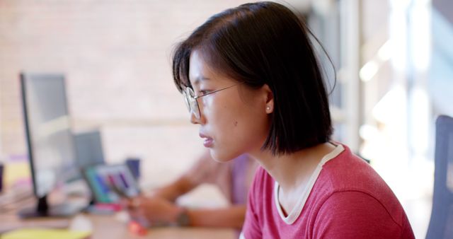 Woman Wearing Glasses Focused on Work at Office Desk - Download Free Stock Photos Pikwizard.com