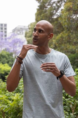 Expressive african american man gesturing while speaking in urban park