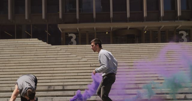 Young people enjoying colorful smoke bombs on concrete steps - Download Free Stock Images Pikwizard.com