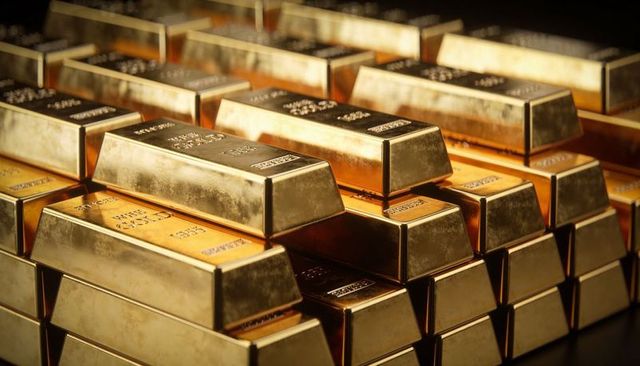 Gleaming stacked gold bars reflecting light with stamped purity marks in secure vault