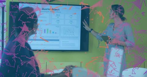 Presenter pointing at quarter report dashboard during team meeting with pink data overlay