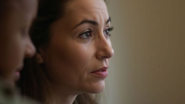 Contemplative woman gazing sideways in soft side light closeup emotional domestic portrait
