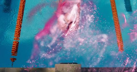 Female swimmer powering through turquoise lane with vivid pink splash and motion