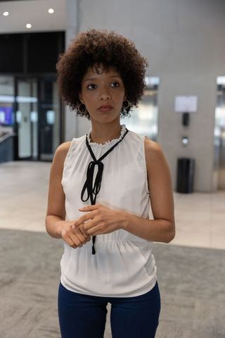 Professional Woman Waiting by Elevator in Modern Office Lobby