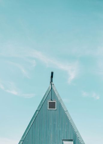 Minimalistic a-frame house against blue sky
