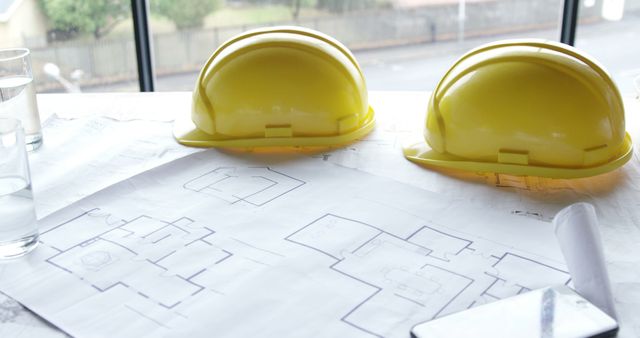 Architectural blueprints with yellow safety helmets on table - Download Free Stock Images Pikwizard.com