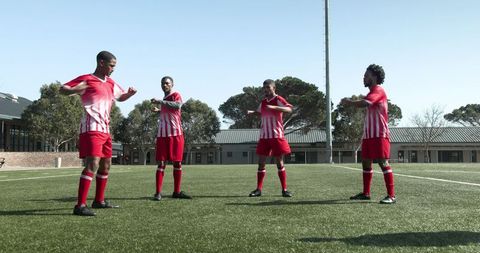 Youth Soccer Players Stretching and Warming Up on Field Before Match