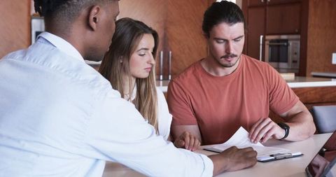 Diverse Team Collaborating on Project with Laptops and Documents
