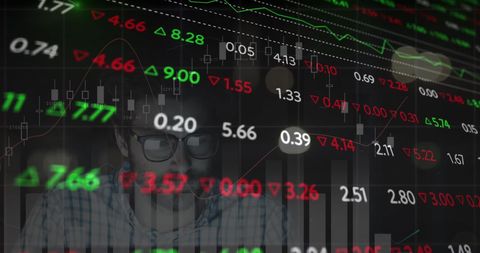 Focused businessman analyzing stock market data overlaid with trading graphs