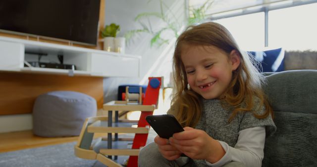 Happy Child Using Smartphone in Living Room - Download Free Stock Images Pikwizard.com