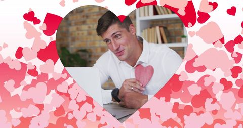 Man on Laptop Video Call Holding Heart with Romantic Heart Overlay