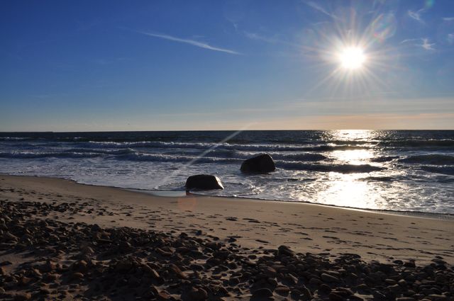 Sunny Beach with Calm Ocean Waves and Rocky Shoreline - Download Free Stock Photos Pikwizard.com
